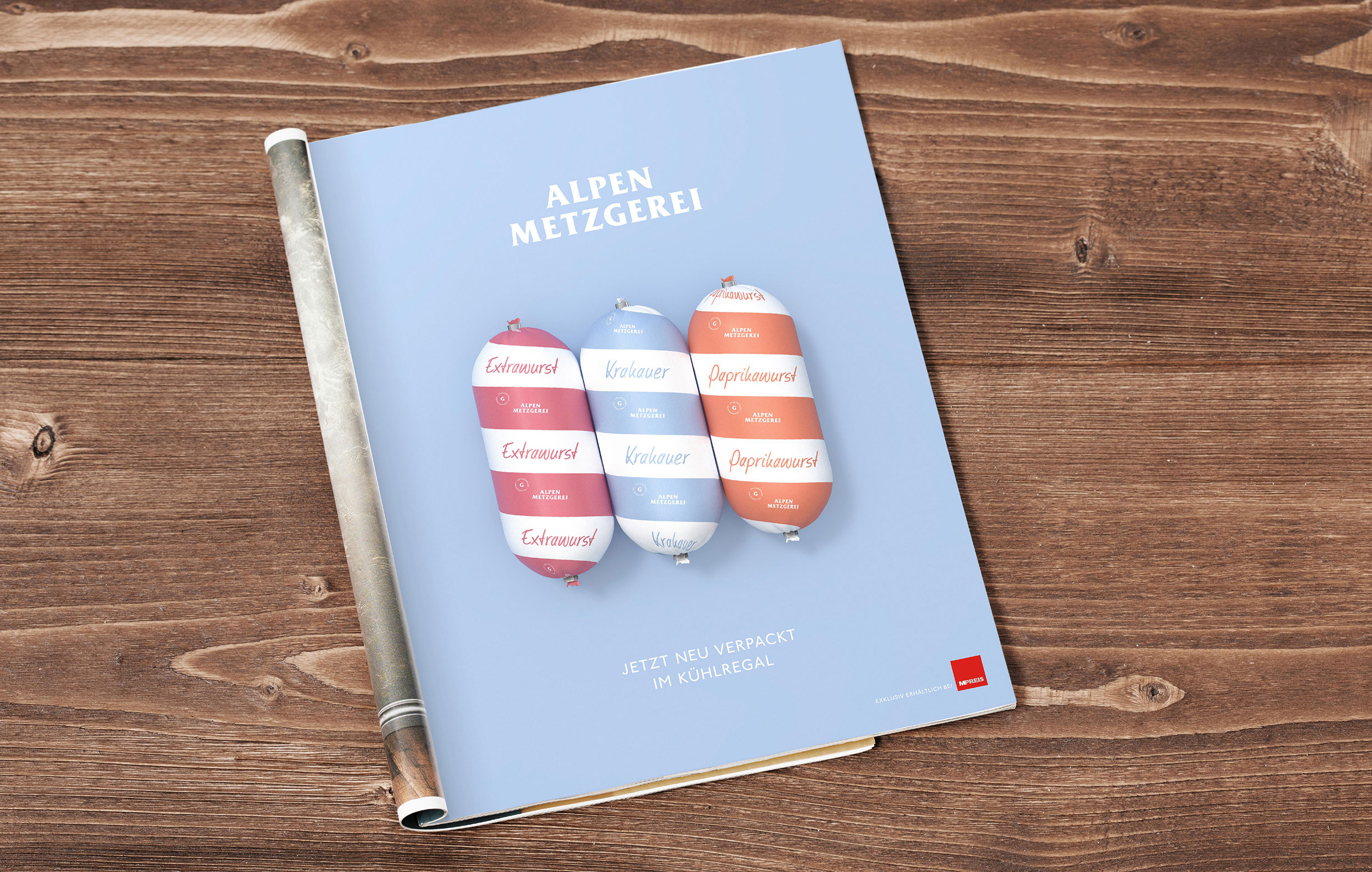 Ein Magazin von Alpen Metzgerei, das Extrawurst, Krakauer und Paprikawurst zeigt. Der Text lautet "Jetzt neu verpackt im Kühlregal".