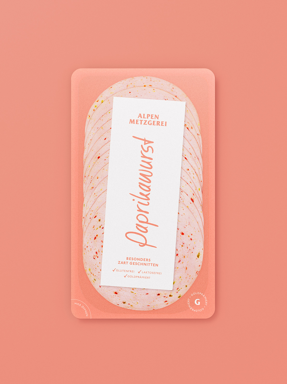 Paprikawurst von Alpen Metzgerei in zarten Scheiben auf einem lachsfarbenen Hintergrund. Gluten- und laktosefrei.